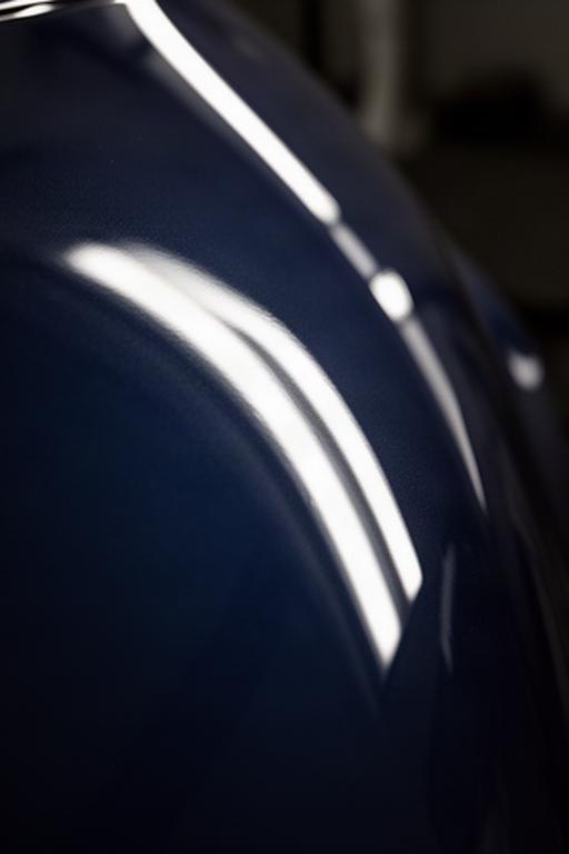 Close-up of dark blue automotive paint with a swirl-free high gloss finish under LED lighting